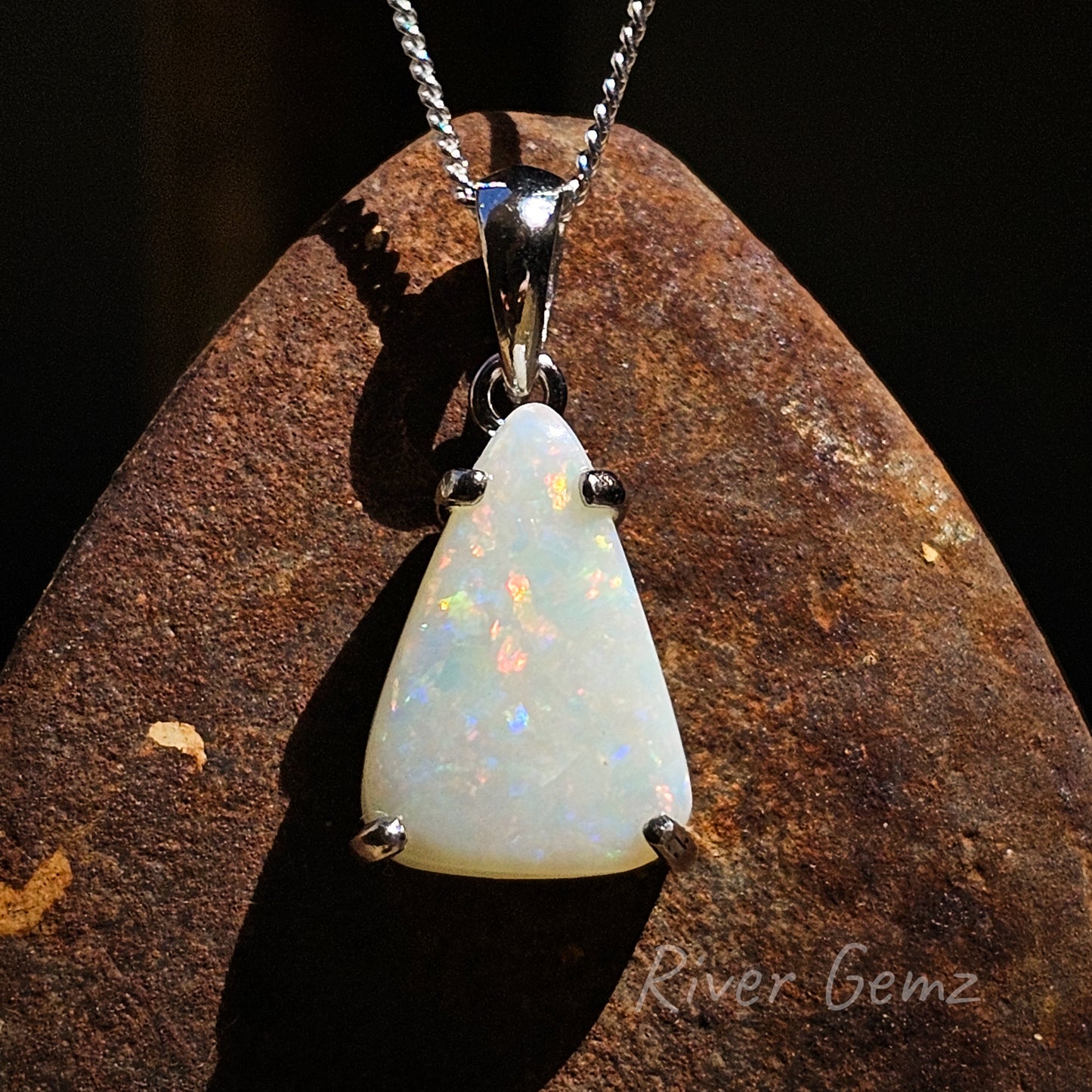 Triangular shaped white opal claw set in silver necklace with large tapered bail.