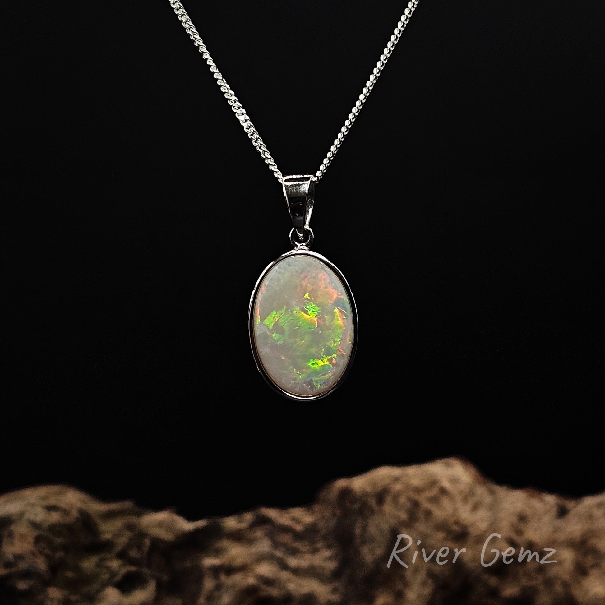 Multi-coloured oval shaped light opal besel set in silver necklace.