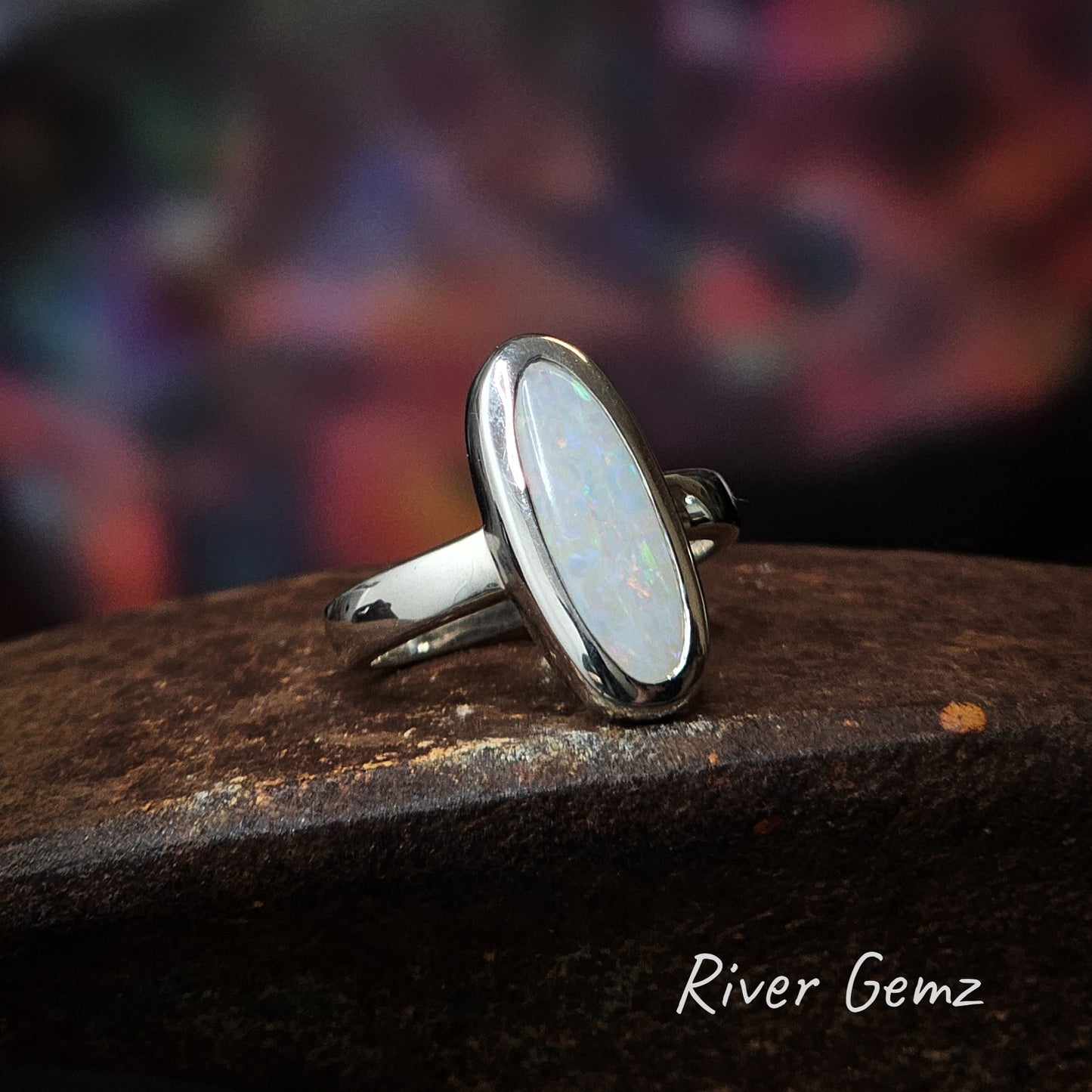 A classically set oval shaped white opal in sterling silver ring.