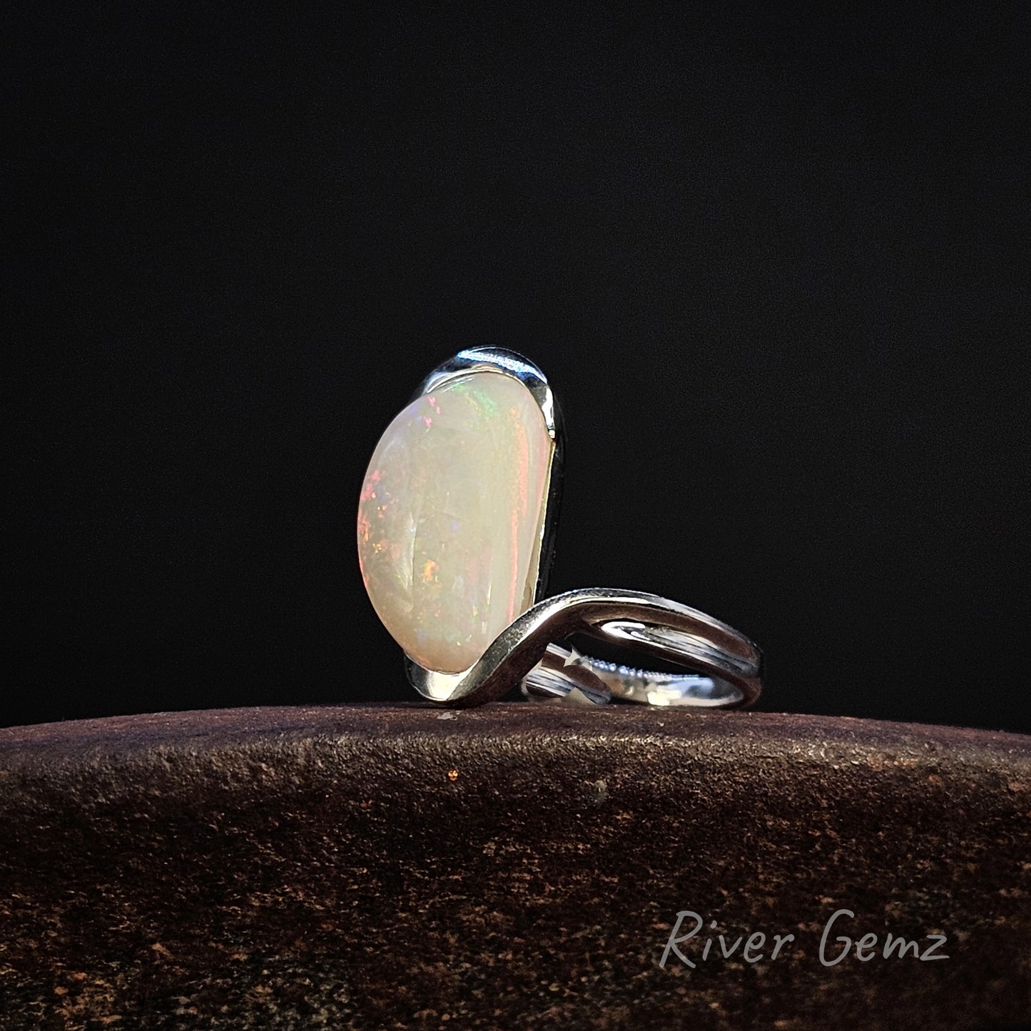 Large white opal partial besel set in sterling silver ring on a dark background, featuring 'River Gemz' branding.