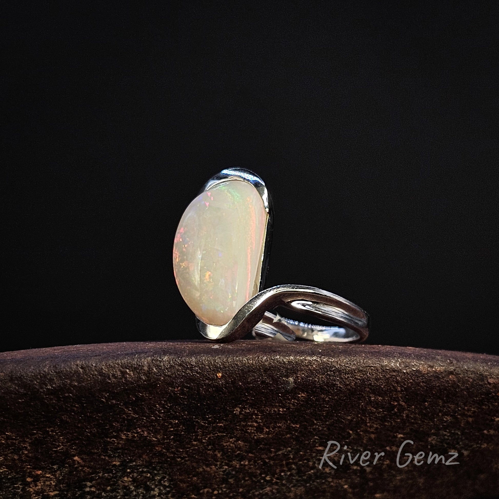 Large white opal partial besel set in sterling silver ring on a dark background, featuring 'River Gemz' branding.
