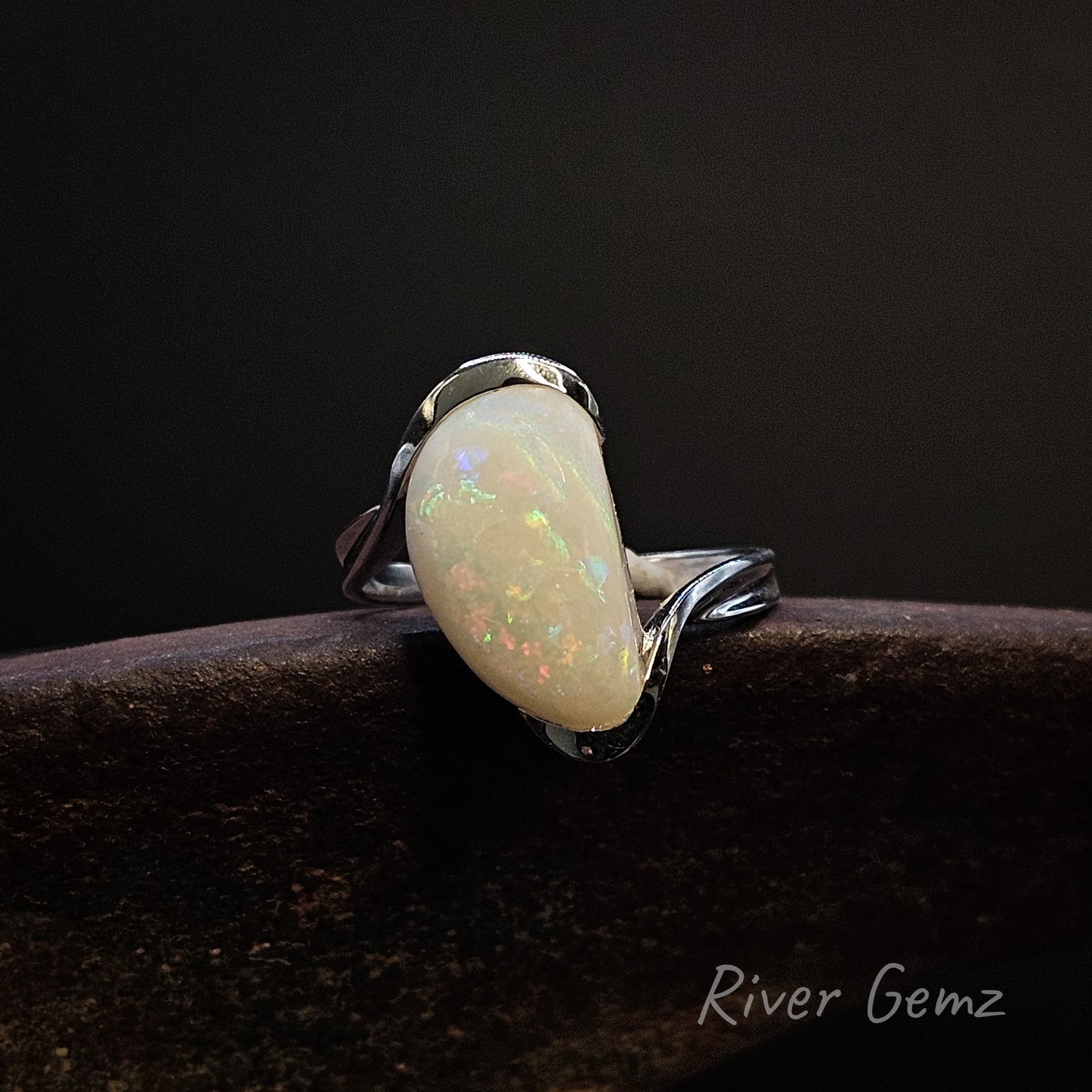 Opal ring on a dark background with 'River Gemz' branding.