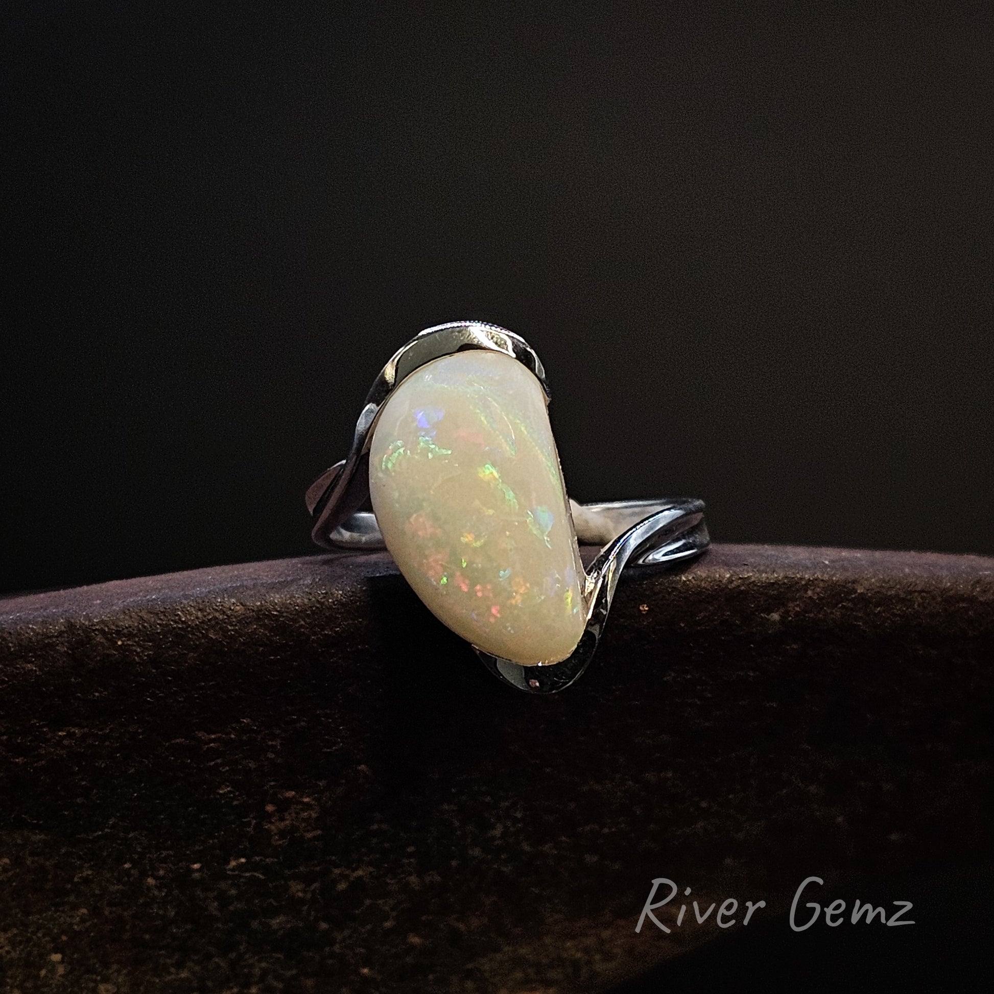 Opal ring on a dark background with 'River Gemz' branding.