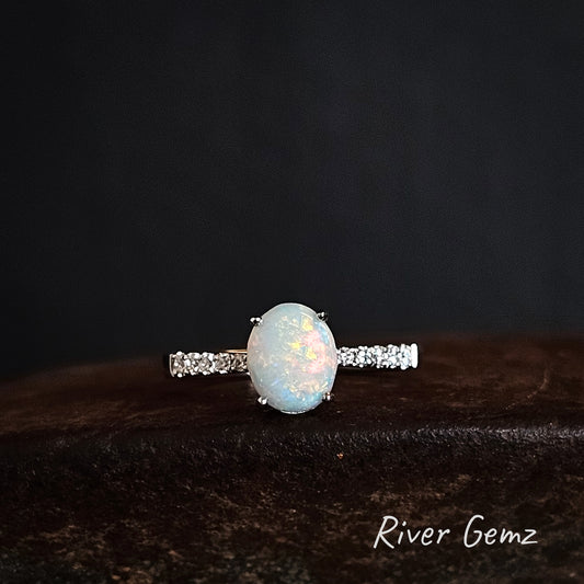 Opal ring with white topaz on a dark background, branded 'River Gemz'.