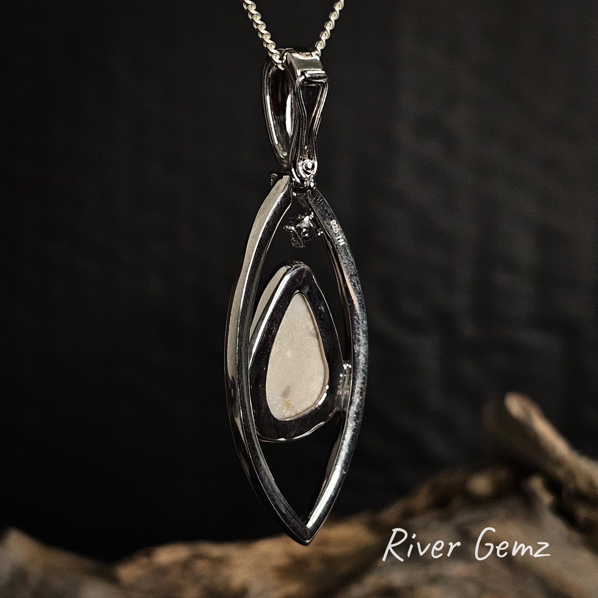 Rear view showing the white base tone of the light opal set in the sterling silver necklace.