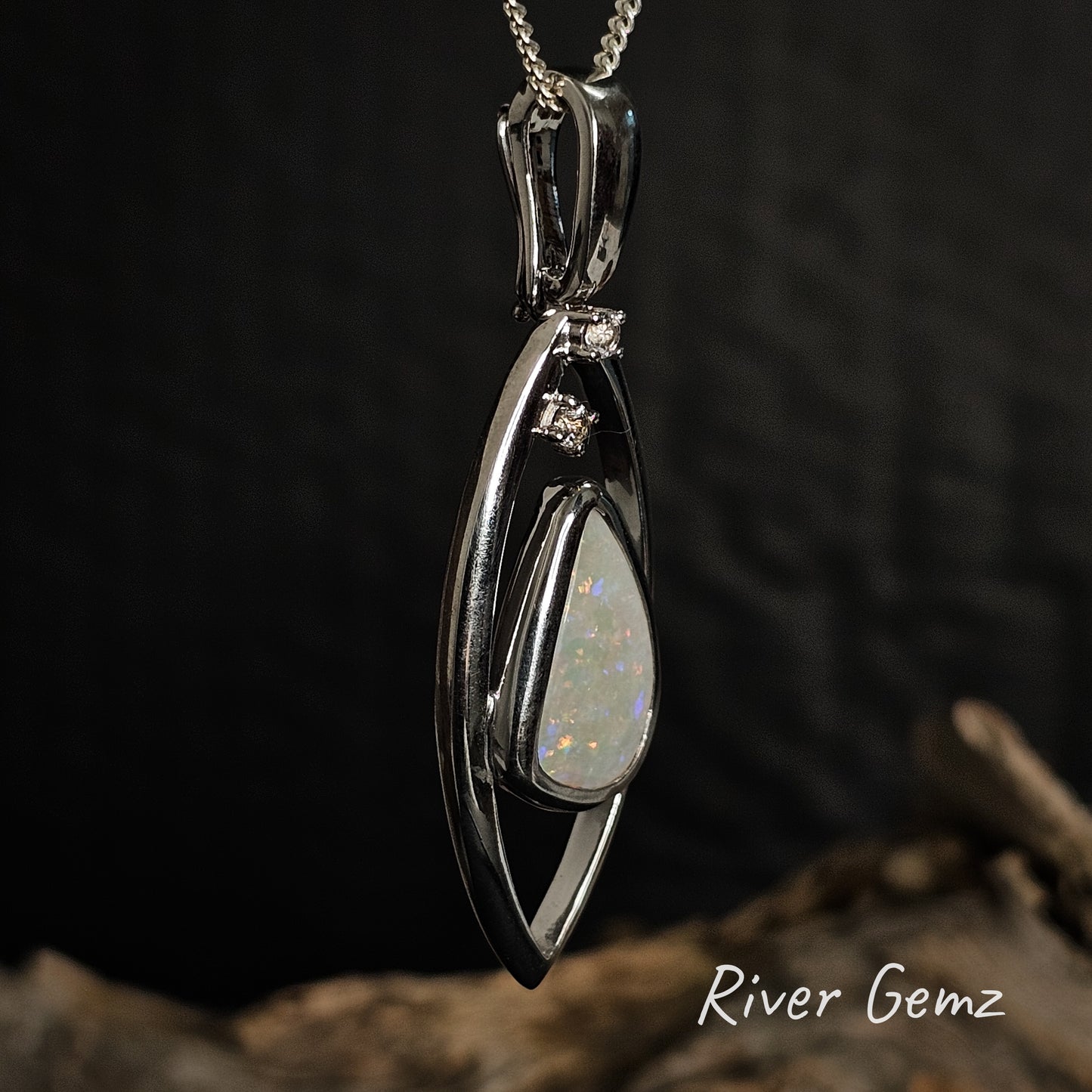 Side view of the light opal and topaz silver necklace showing the large bail.