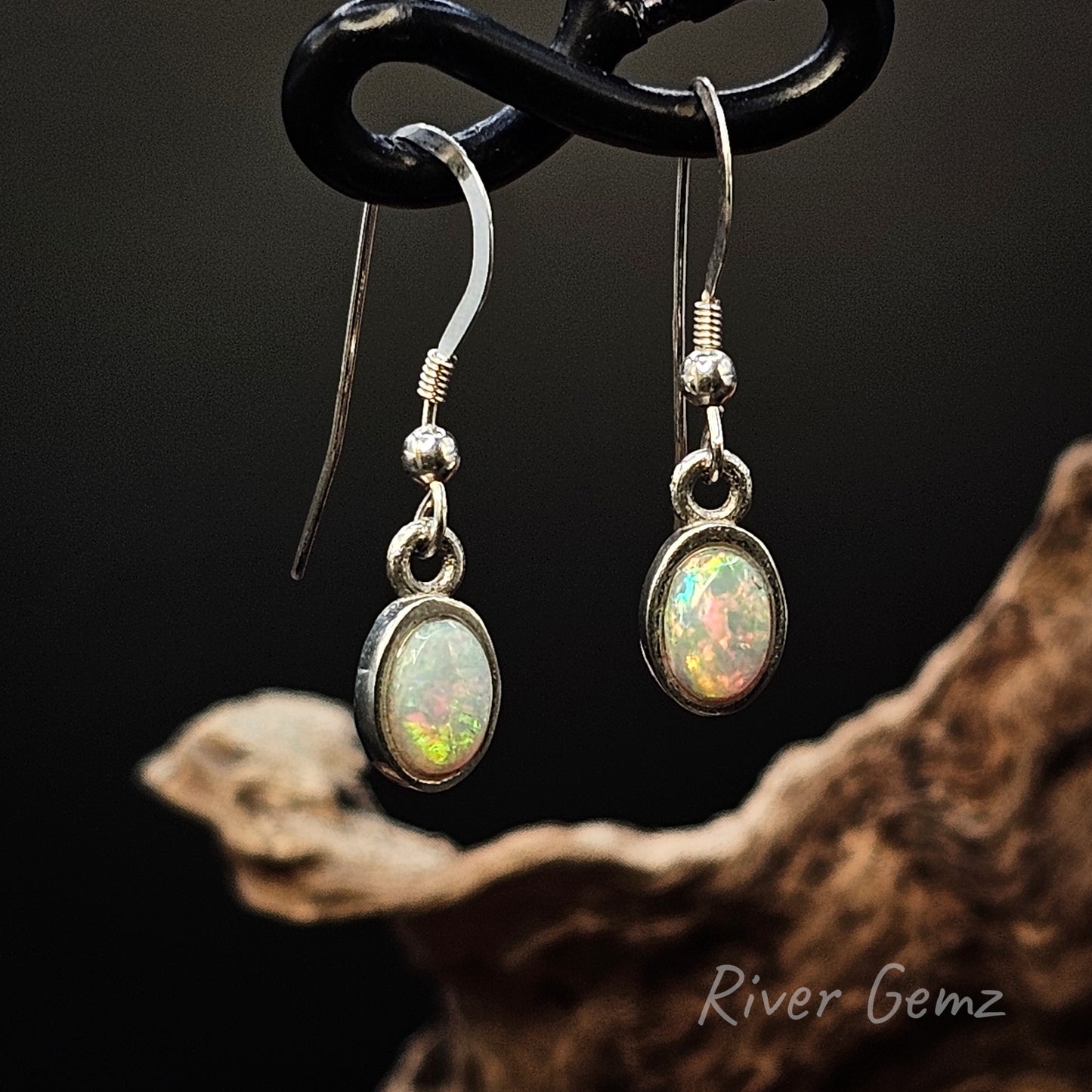 Oval shaped white opals set in long sterling silver hooks.
