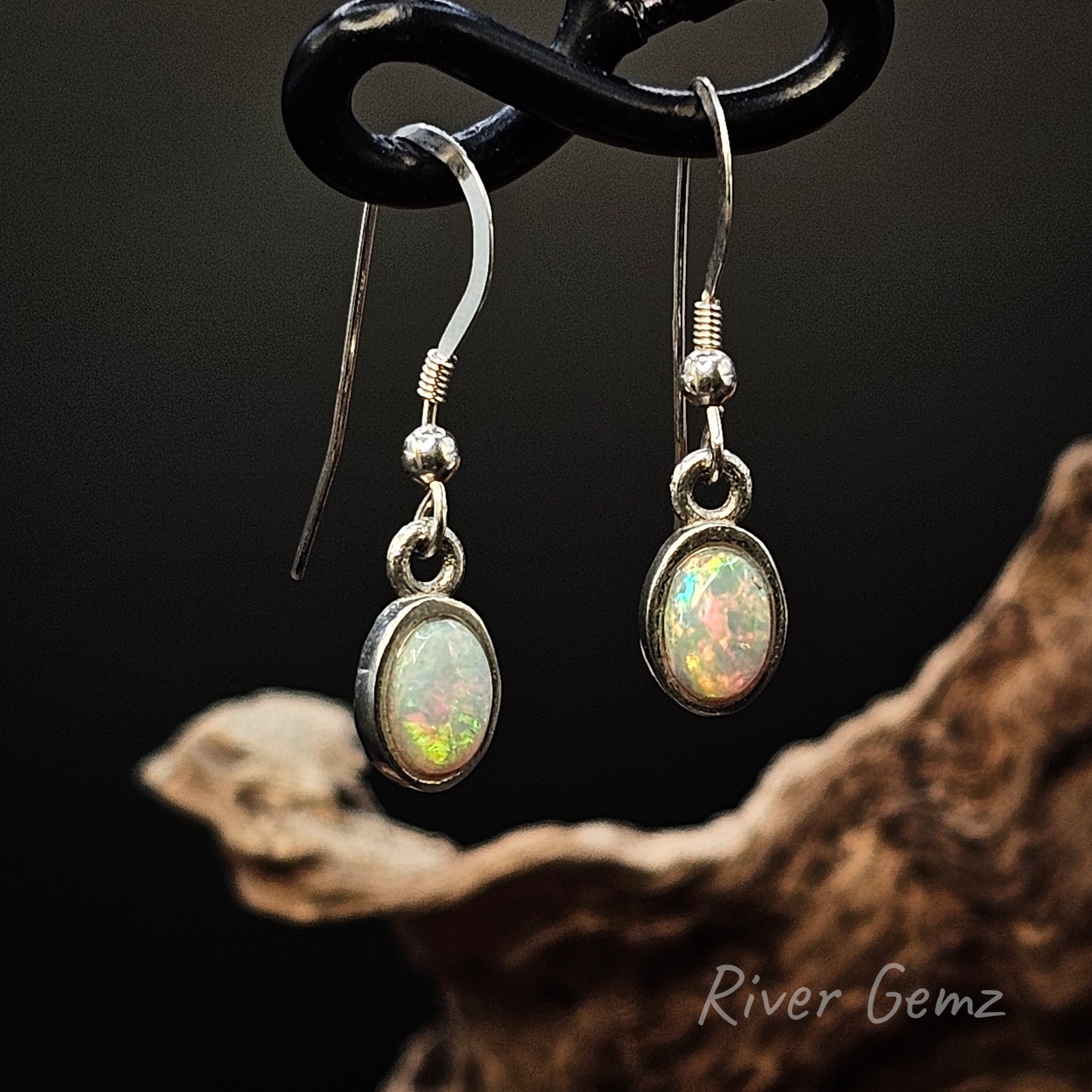 Oval shaped white opals set in long sterling silver hooks.