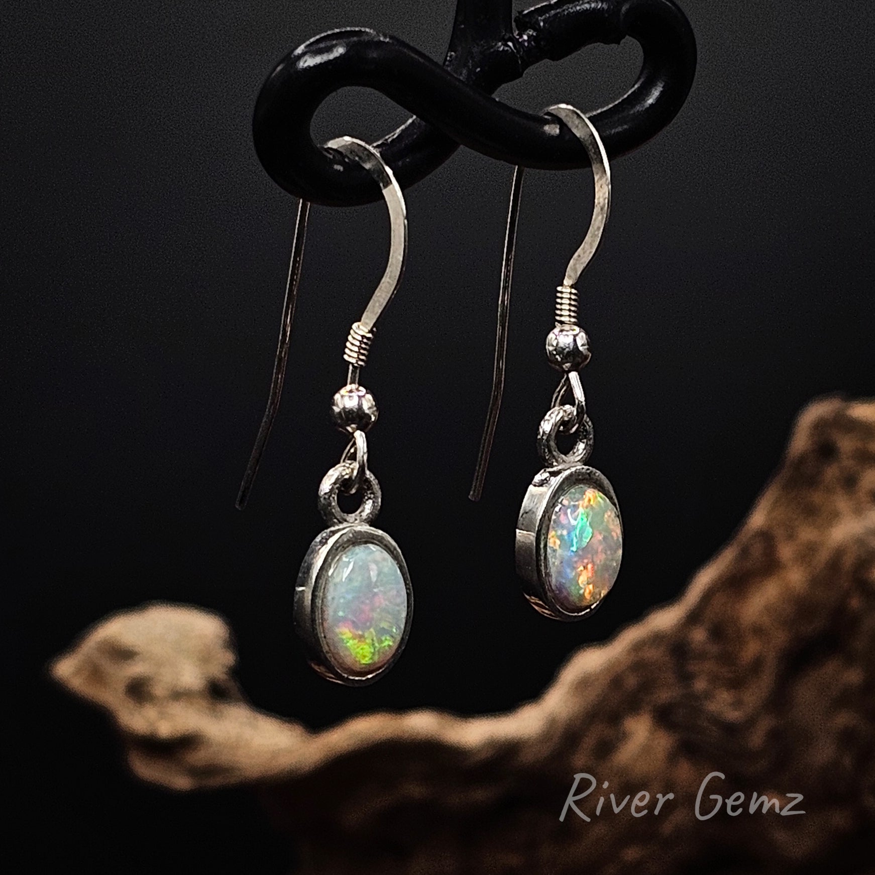 HIgh domed multi-coloured white opals besel set in silver French hooks.