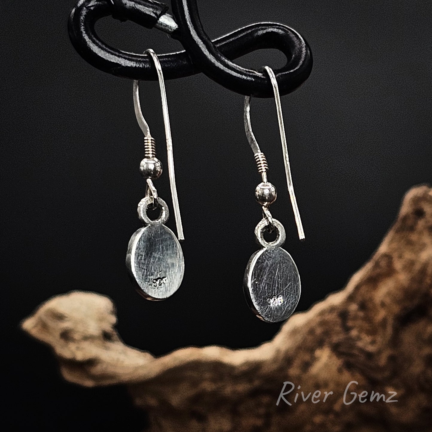 Rear view of shepherd hook earrings shows the full silver backing behind the white opals.