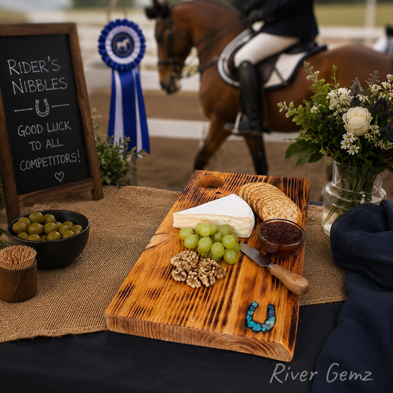 Cheeseboard with grapes, crackers, and a horse-themed table with a chalkboard sign and horse in the background.