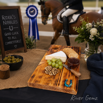 Cheeseboard with grapes, crackers, and a horse-themed table with a chalkboard sign and horse in the background.