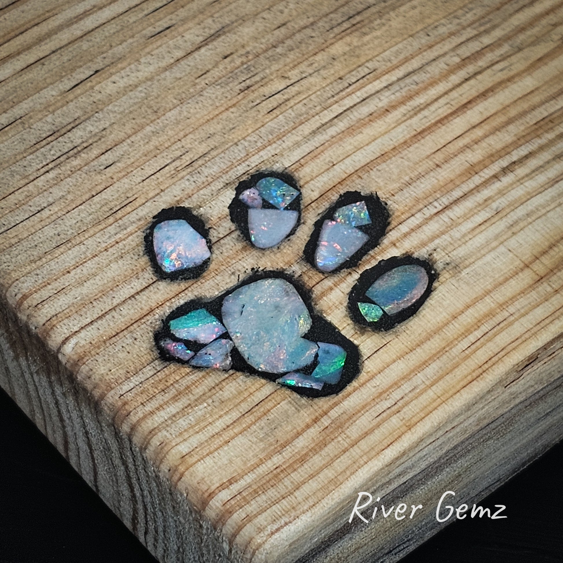 Close up showing the 14 opal slices used to create the paw print mosaic.