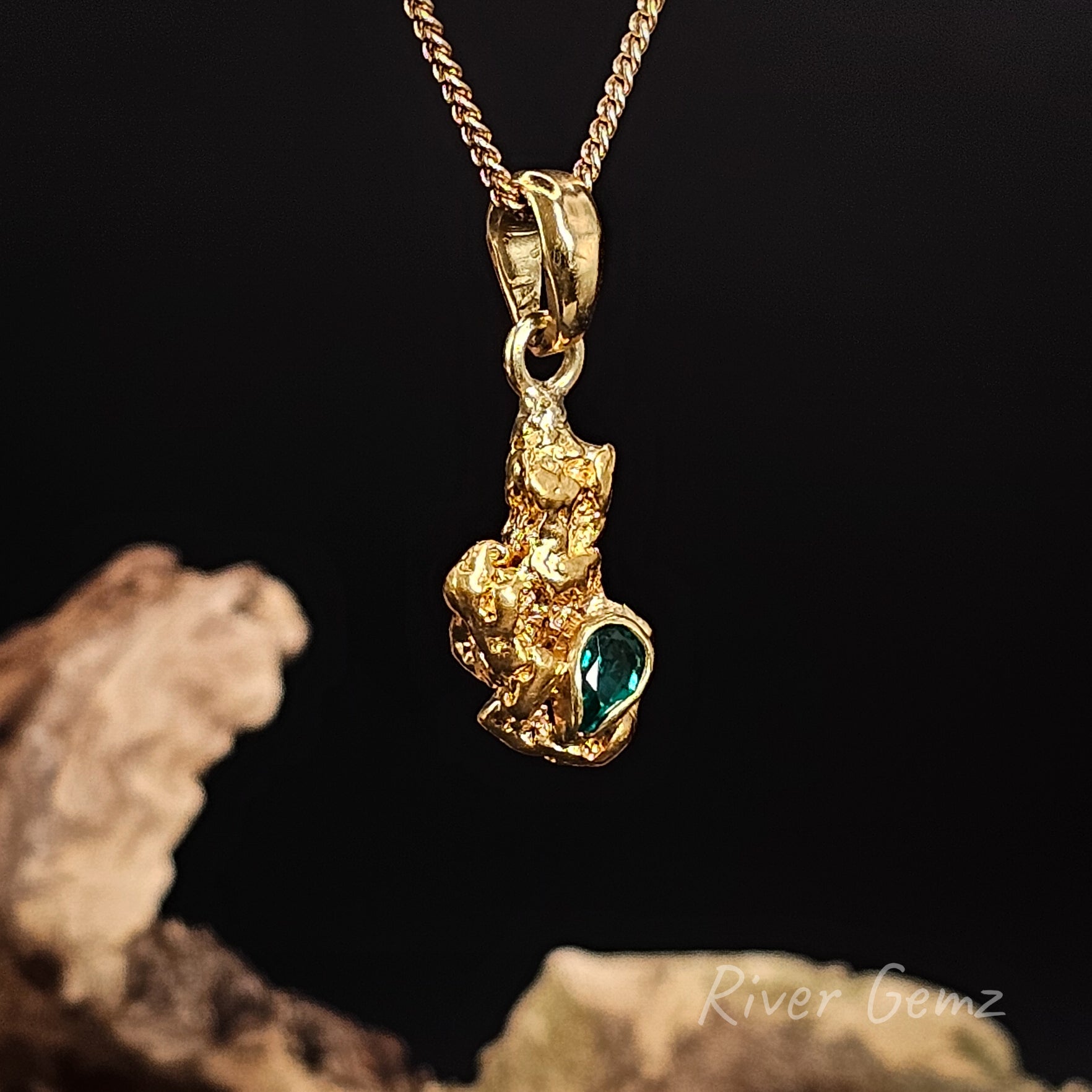Gold nugget and emerald set in 18K yellow gold pendant showing the large bail.