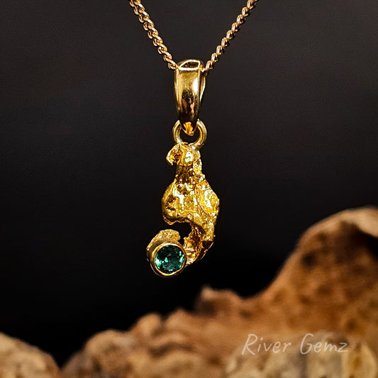 Gold nugget with emerald set in yellow gold pendant.