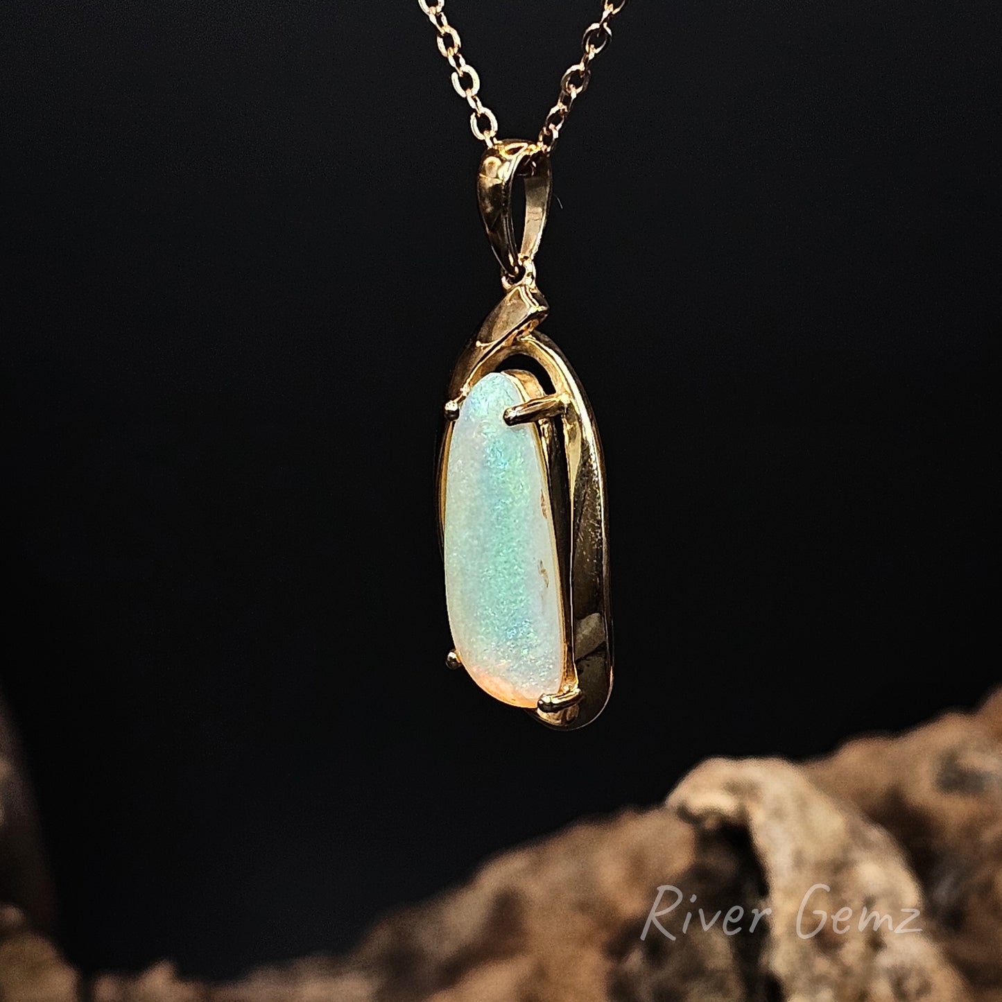 Opal pendant with gold setting on a dark background