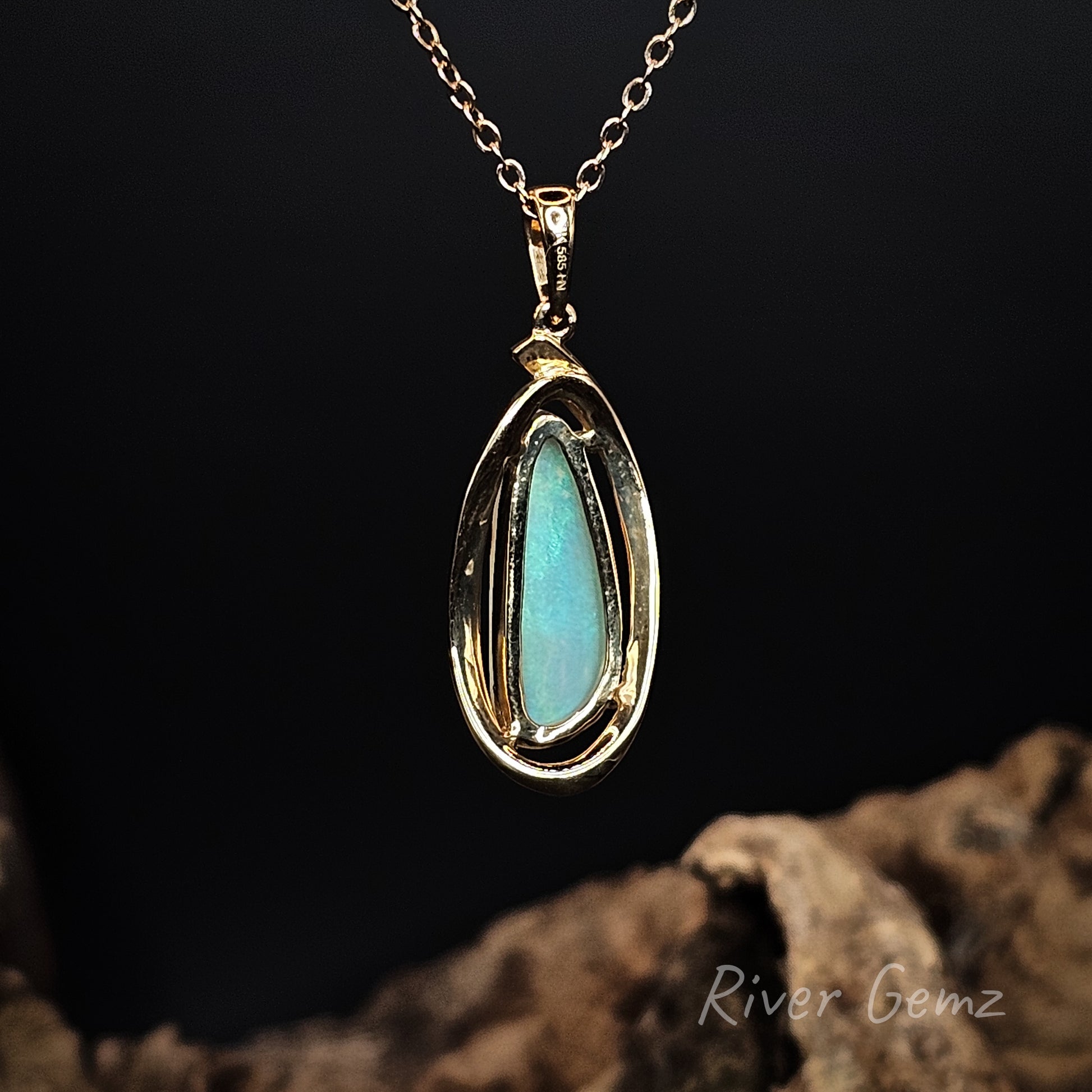 Rear view of yellow gold pendant showing the green colour of the crystal opal permeates the entire stone.