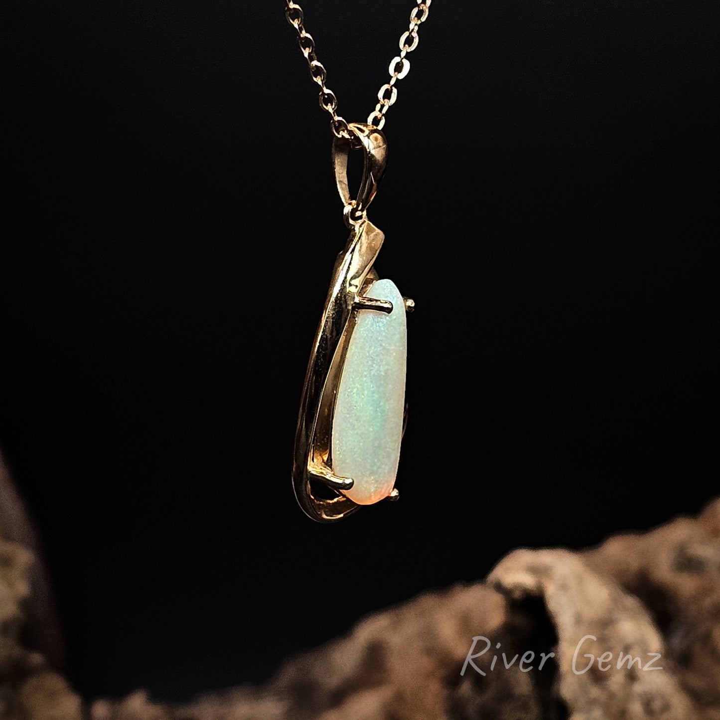Opal pendant on a gold chain with a dark background