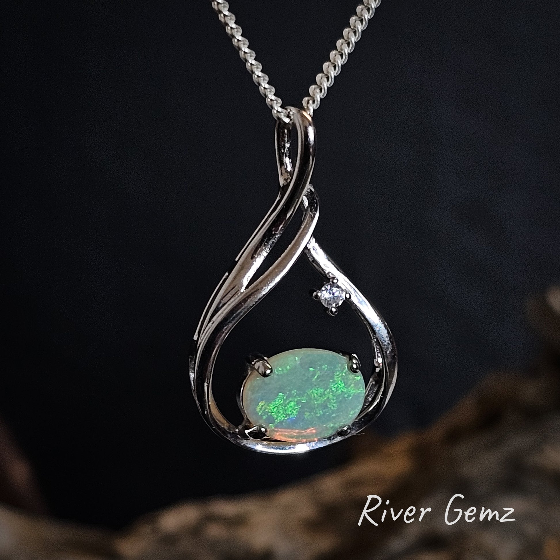Oval shaped green crystal opal with white topaz stone in silver necklace.
