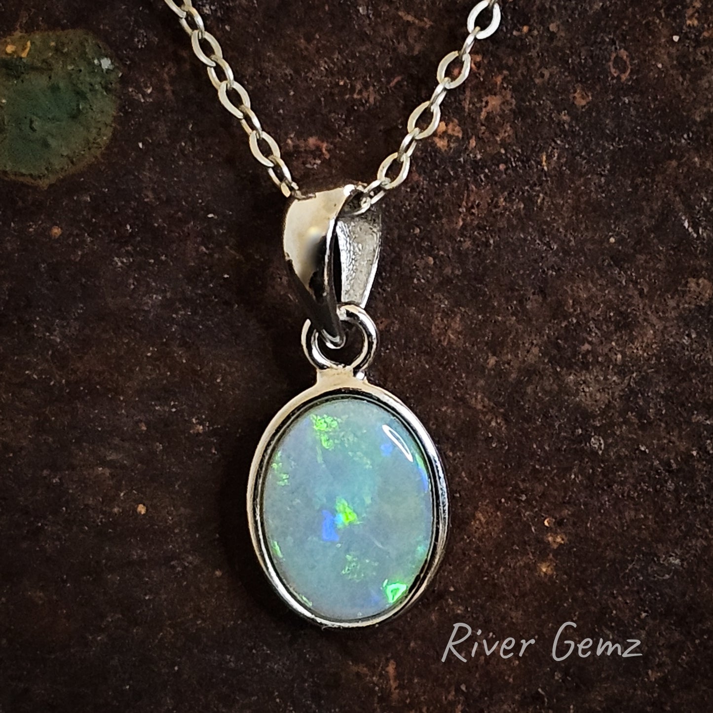 Green and blue crystal opal besel set in sterling silver pendant with large bail.