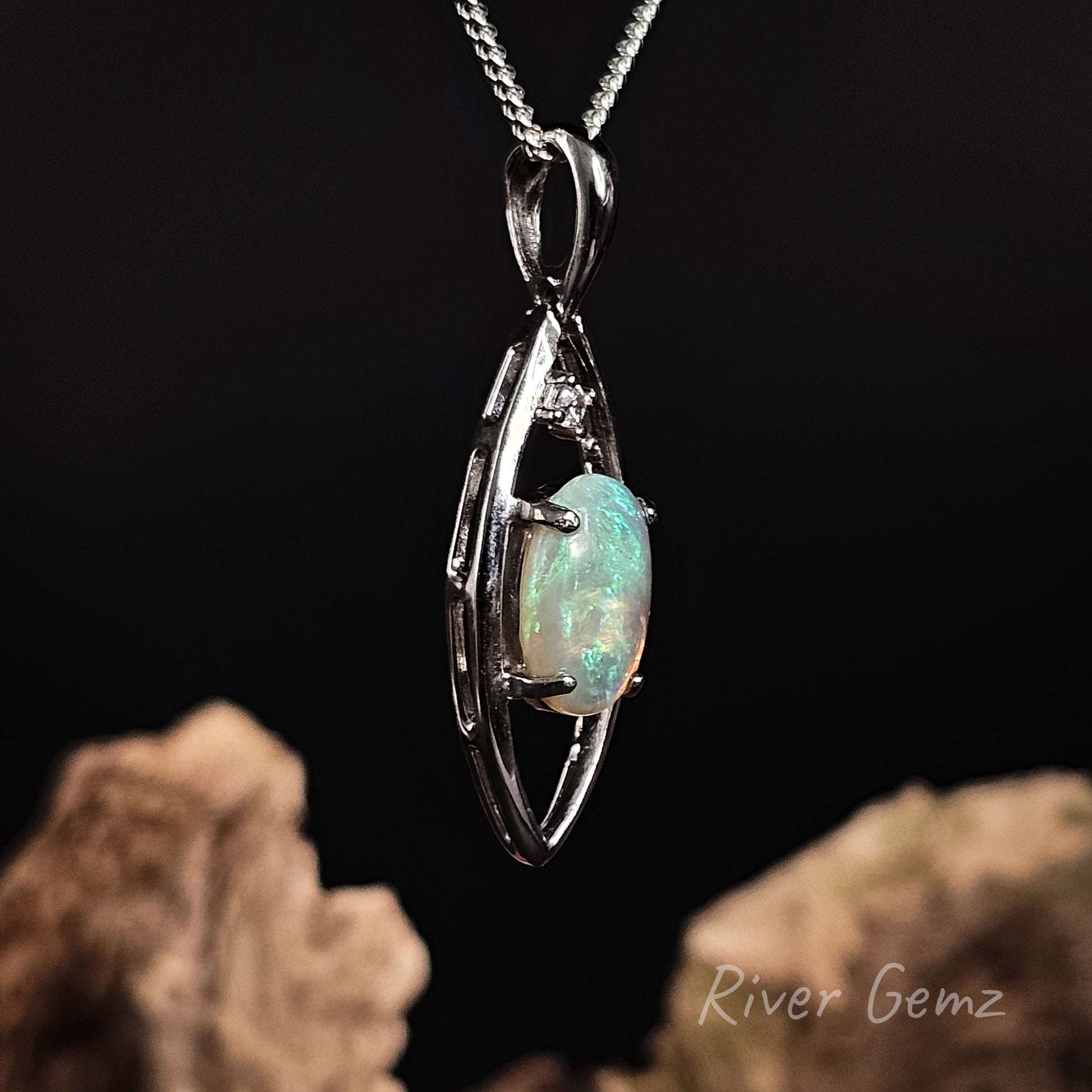 Opal and white topaz stone claw set in sterling silver pendant on a chain with a dark background and 'River Gemz' branding.
