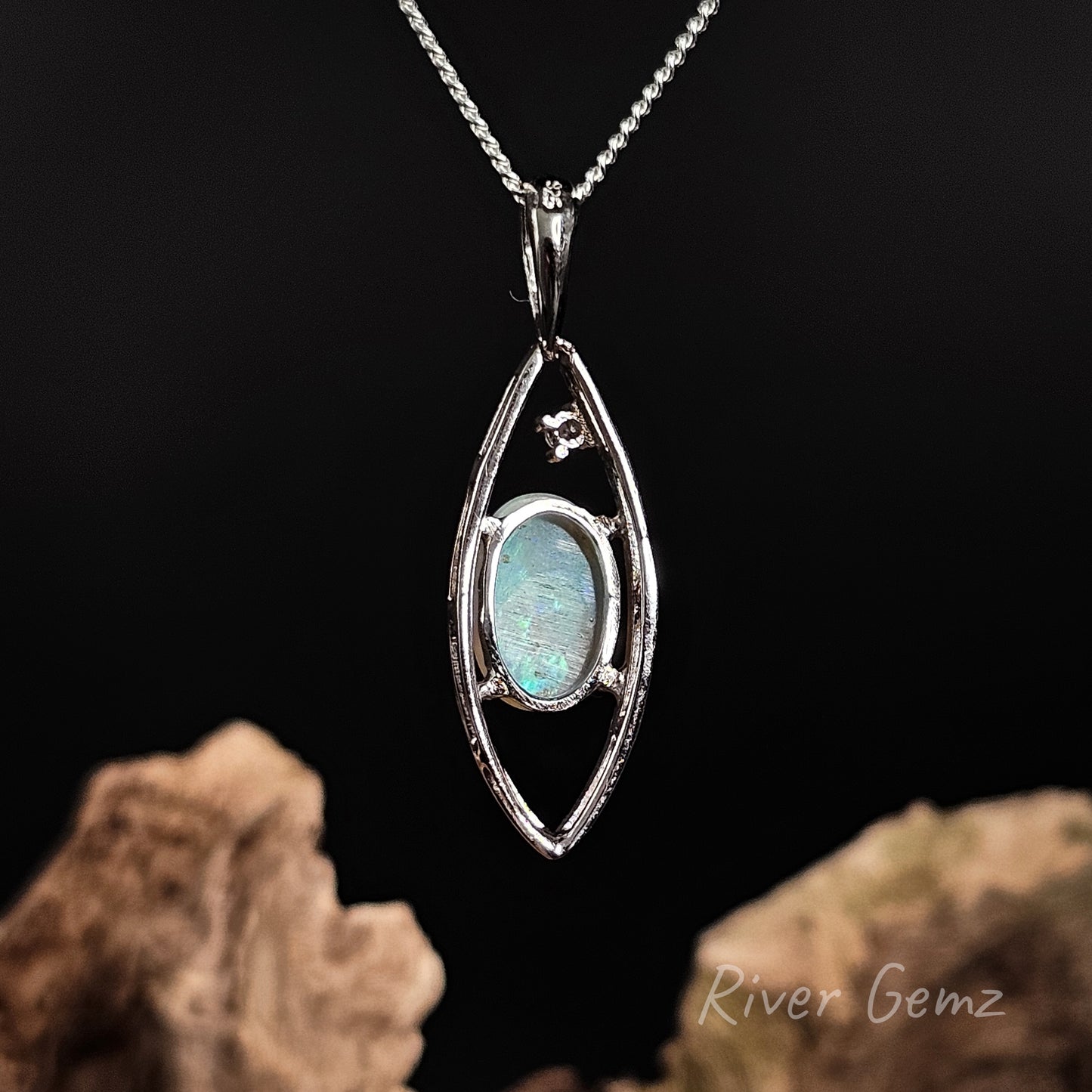 Rear view of pendant shows the light base tone of the crystal opal on a dark background