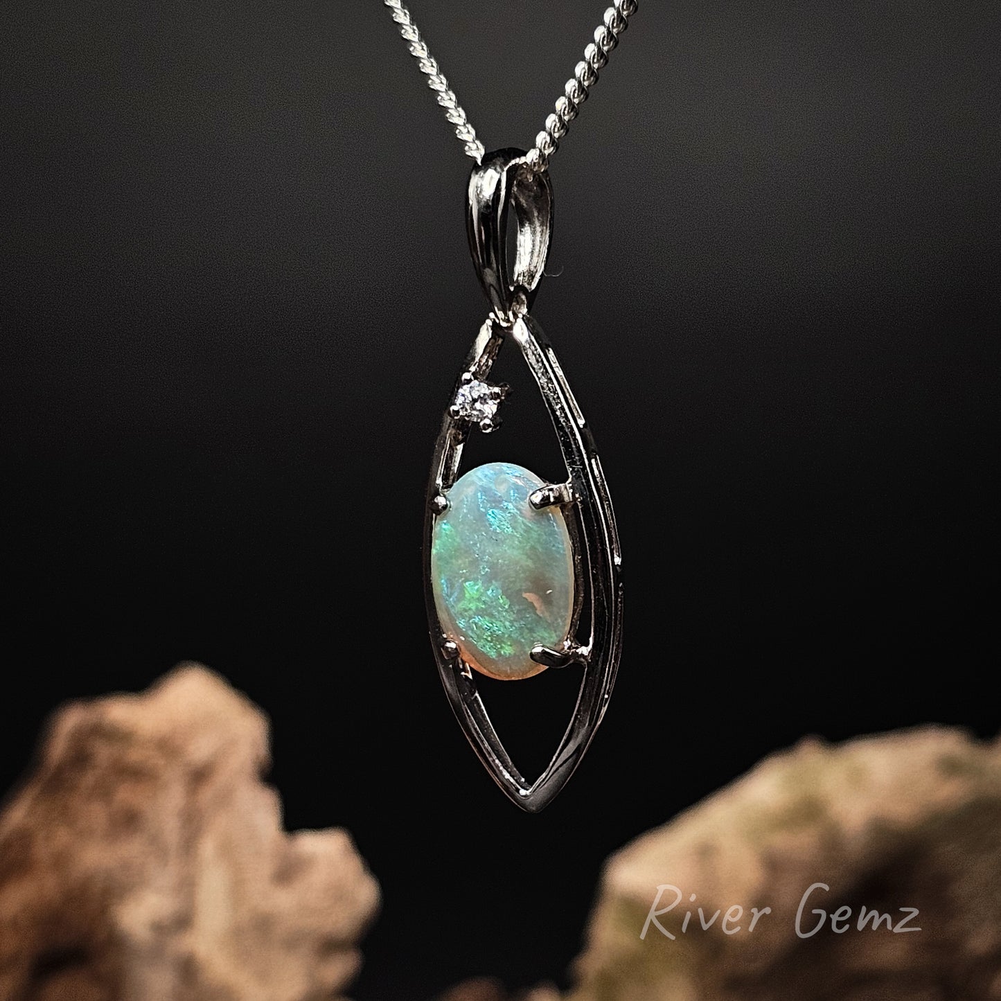 Opal pendant with silver chain on a dark background, featuring 'River Gemz' branding.