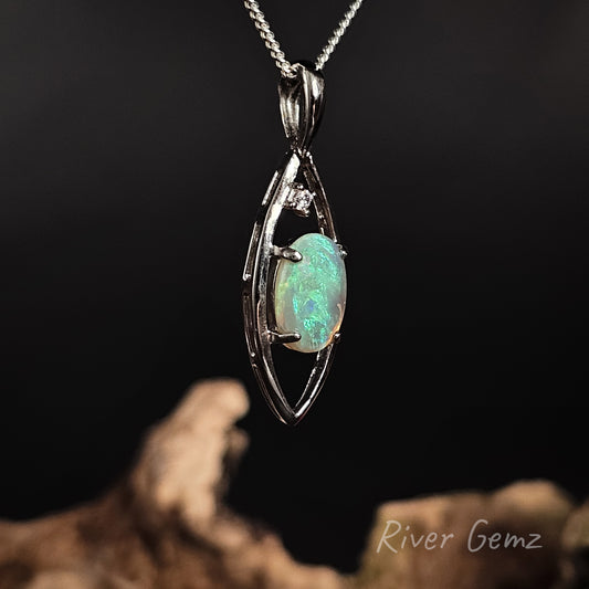 Oval shaped green light opal set in silver necklace on a dark background with 'River Gemz' branding.