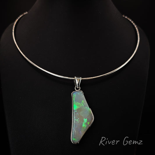 Light opal set in sterling silver pendant hanging on an omega necklace on a black background with 'River Gemz' branding.