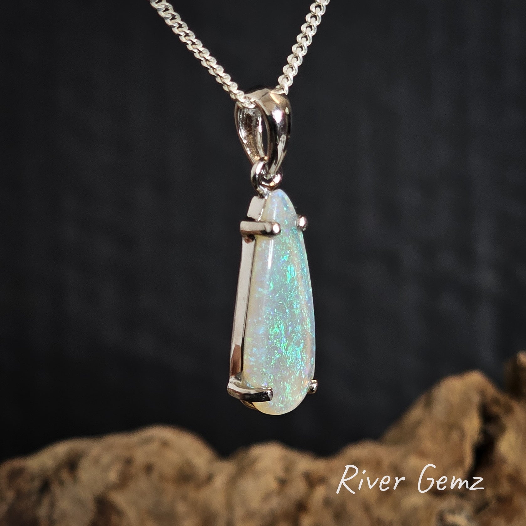 Light green crystal opal silver pendant on a chain with a dark background and 'River Gemz' branding.