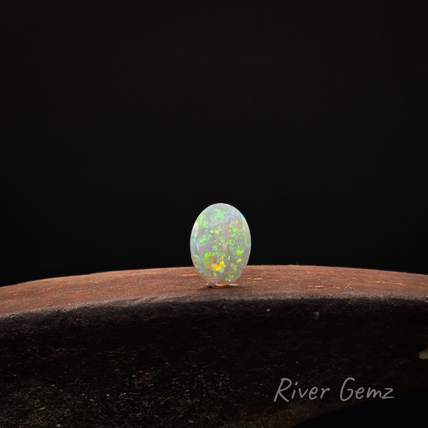 Opal stone on a dark background with 'River Gemz' branding.