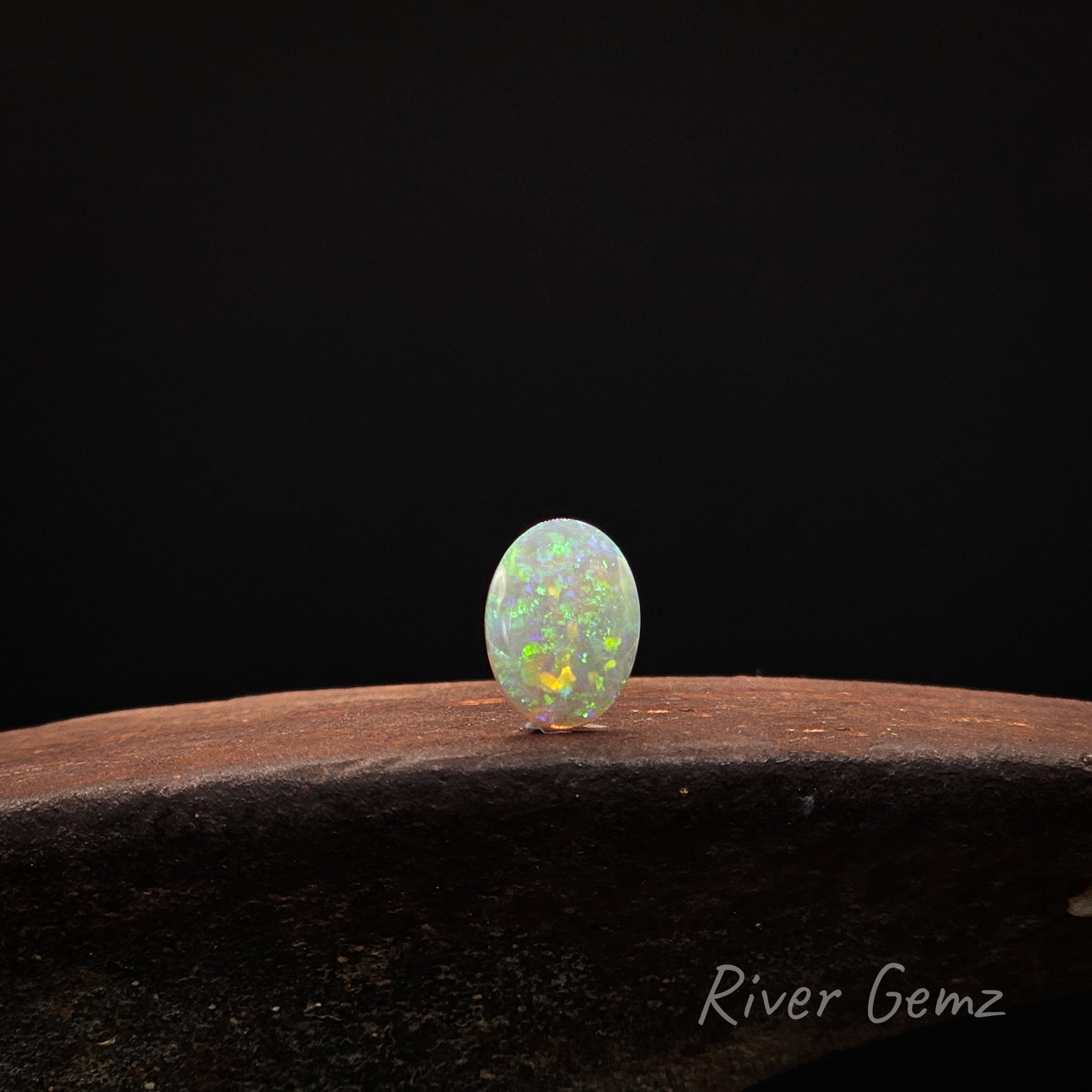 Opal stone on a dark background with 'River Gemz' branding.