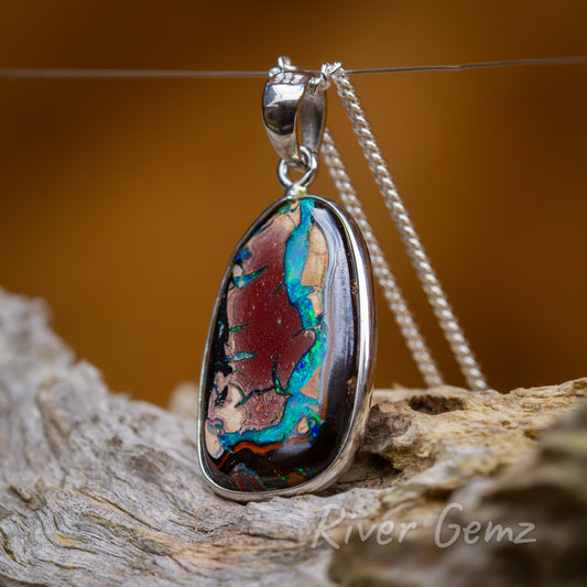 Approximately oval shaped opal with the main vein of colour flowing down one side.