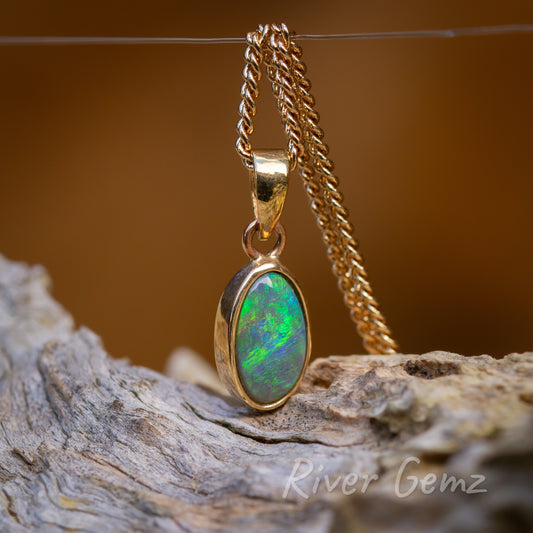 Angled view of oval shaped besel set pendant with large separate bail.