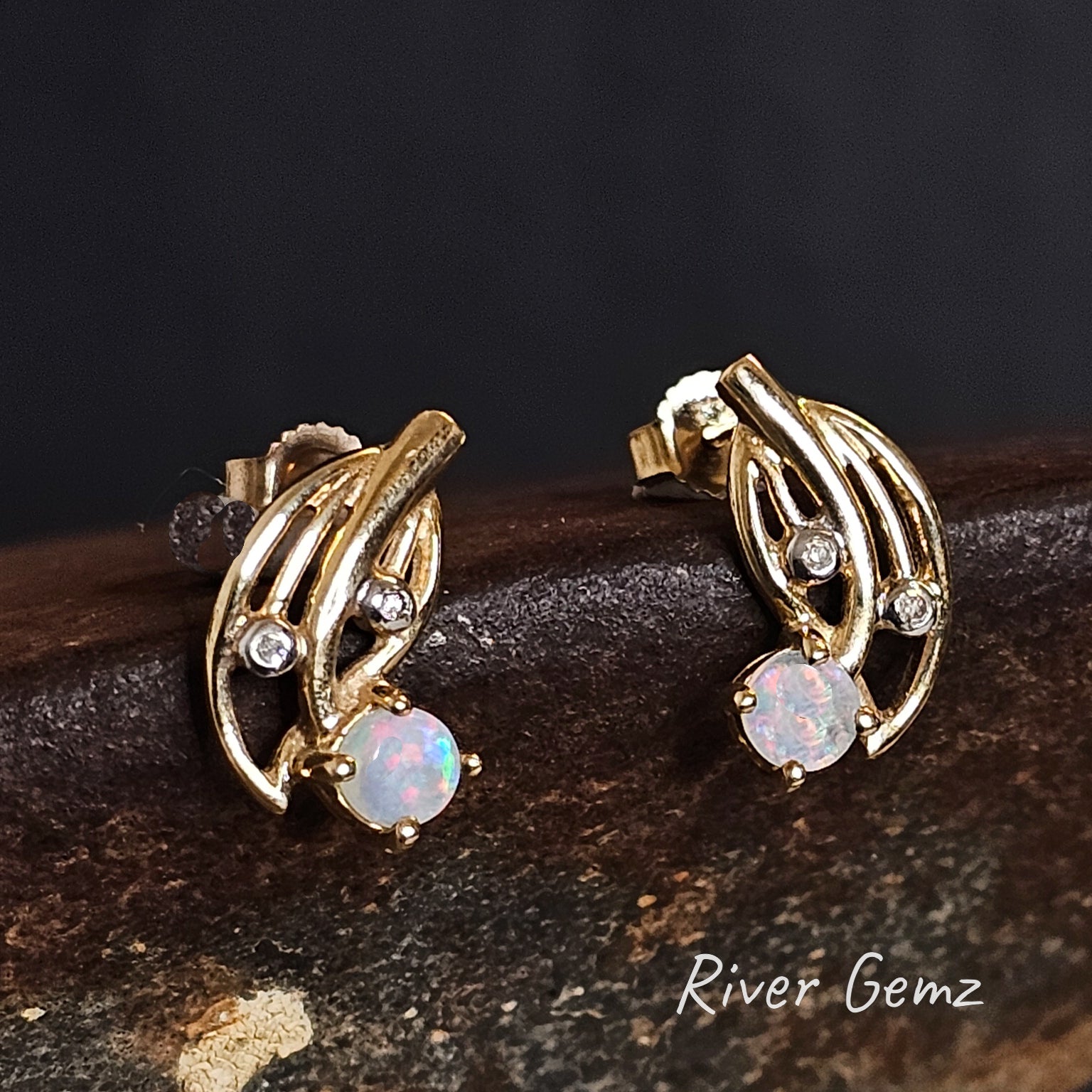 Round light multi-coloured opals claw set in gold earrings with 2 white diamonds.