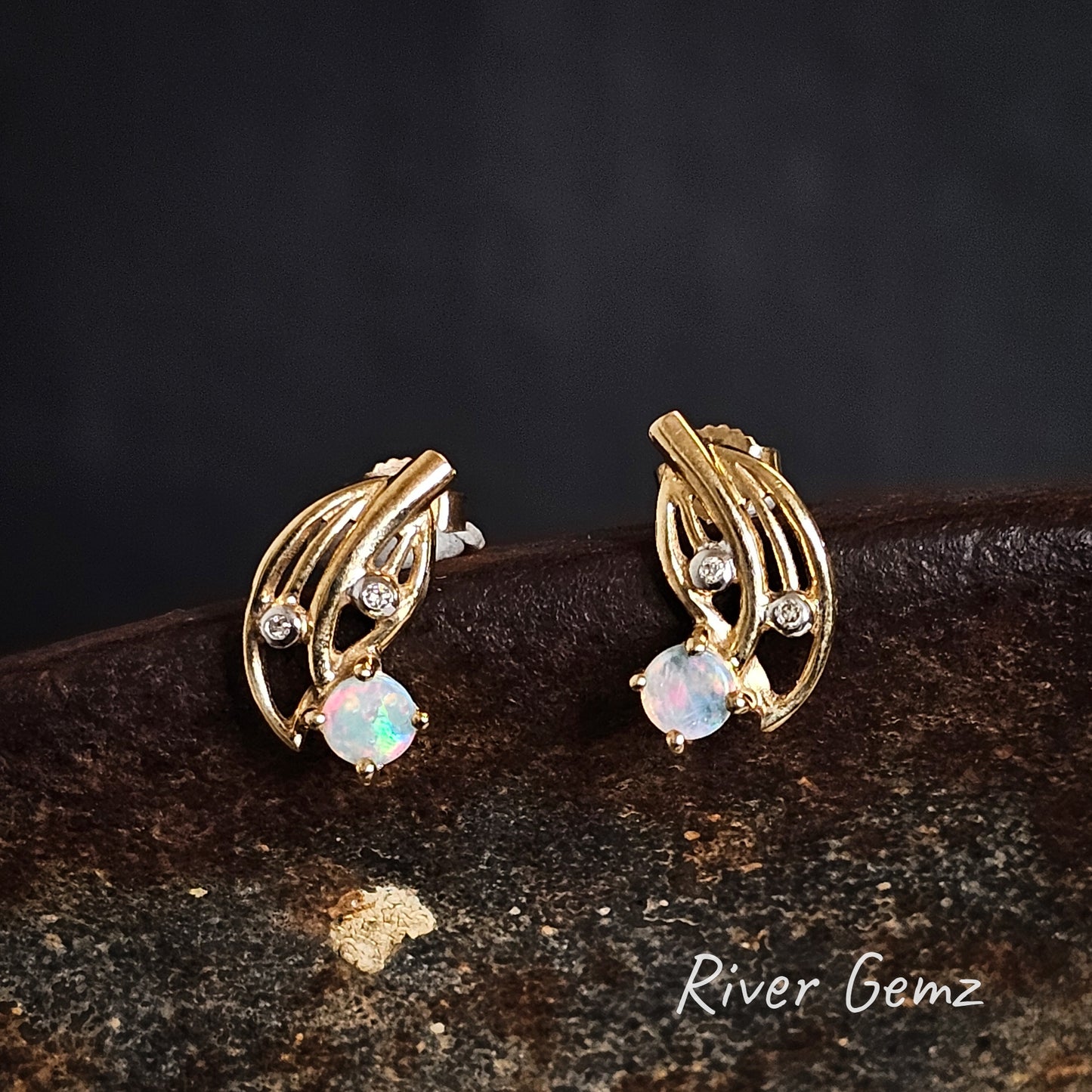 Round light opals claw set in yellow gold earrings with 2 diamonds in each stud.