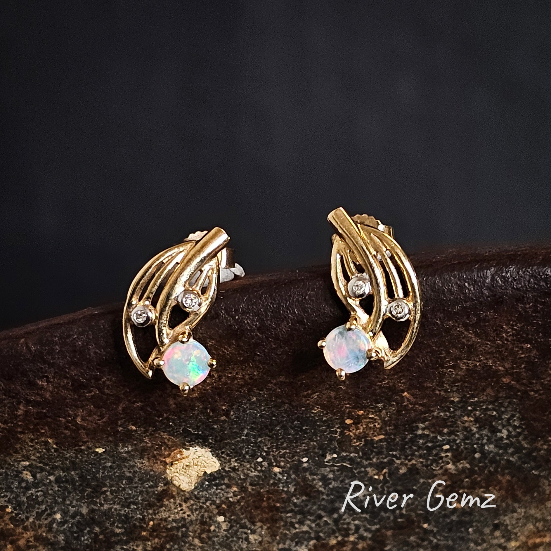 Round light opals claw set in yellow gold earrings with 2 diamonds in each stud.