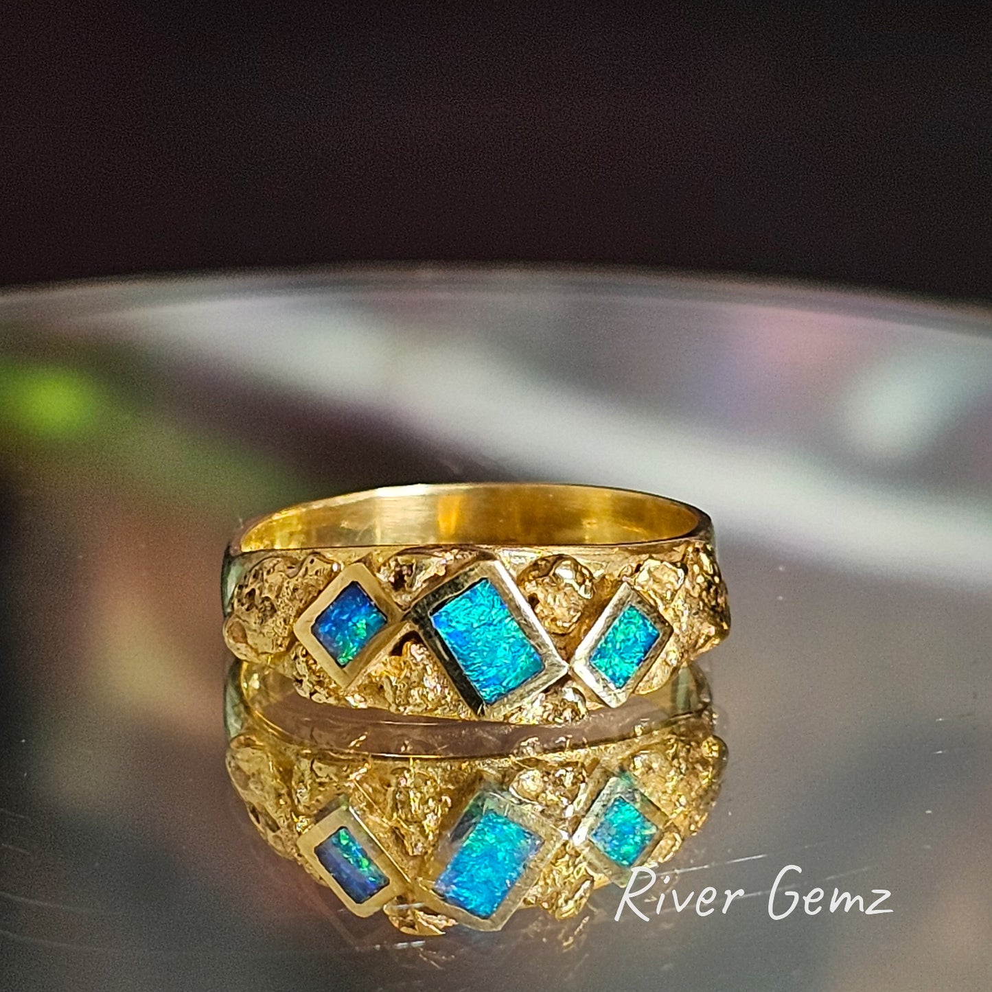 Blue and green opals surrounded by natural nuggets in yellow gold ring.