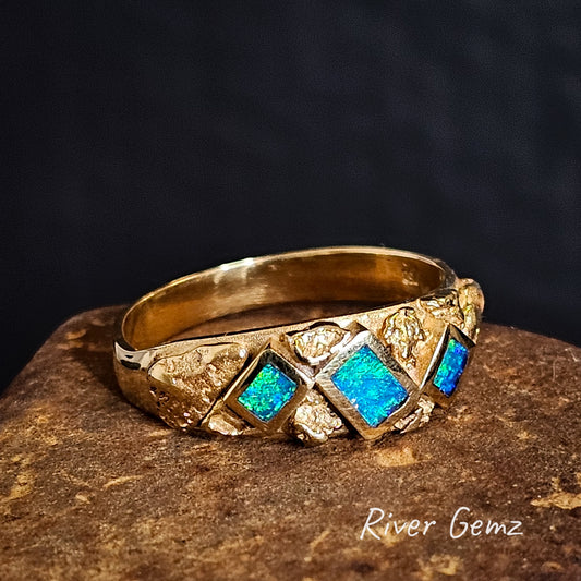 Gold ring with nuggets and 3 blue dark opals on a dark background, branded 'River Gemz'.