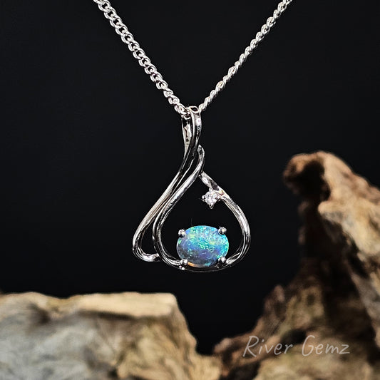 Opal pendant necklace on a chain with a dark background
