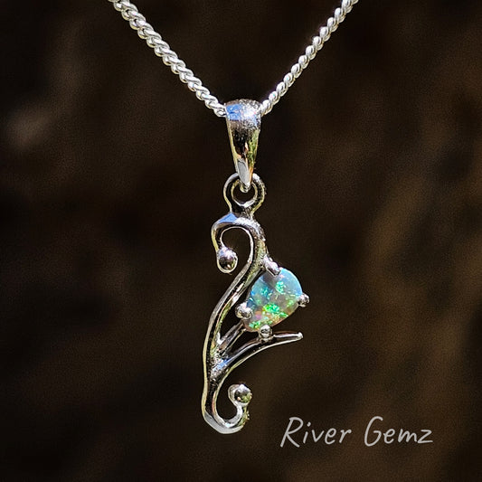 Tear drop shaped dark opal with green and blue colours claw set in a sterling silver pendant.