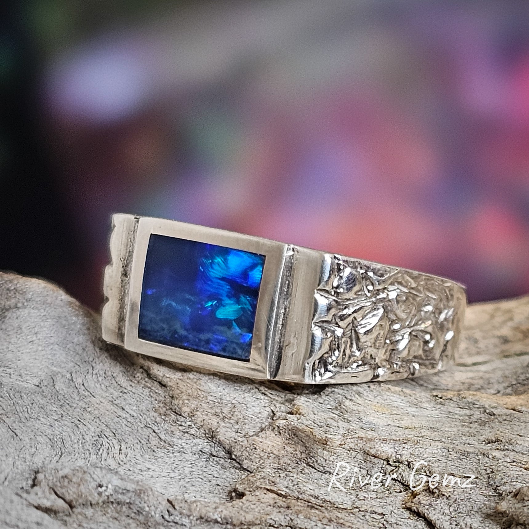 Rectangular shape of the ring extends beyond the opal to include the silver setting.