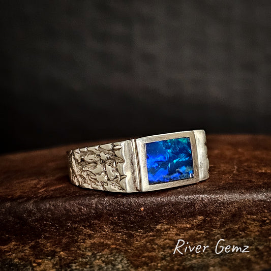 Silver ring with blue opal stone on a dark background, featuring 'River Gemz' branding.