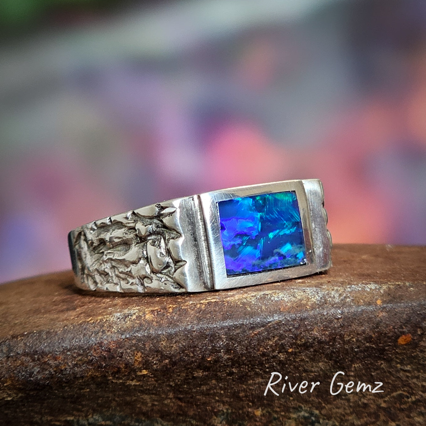 Rectangular blue-purple black opal in men's silver ring.