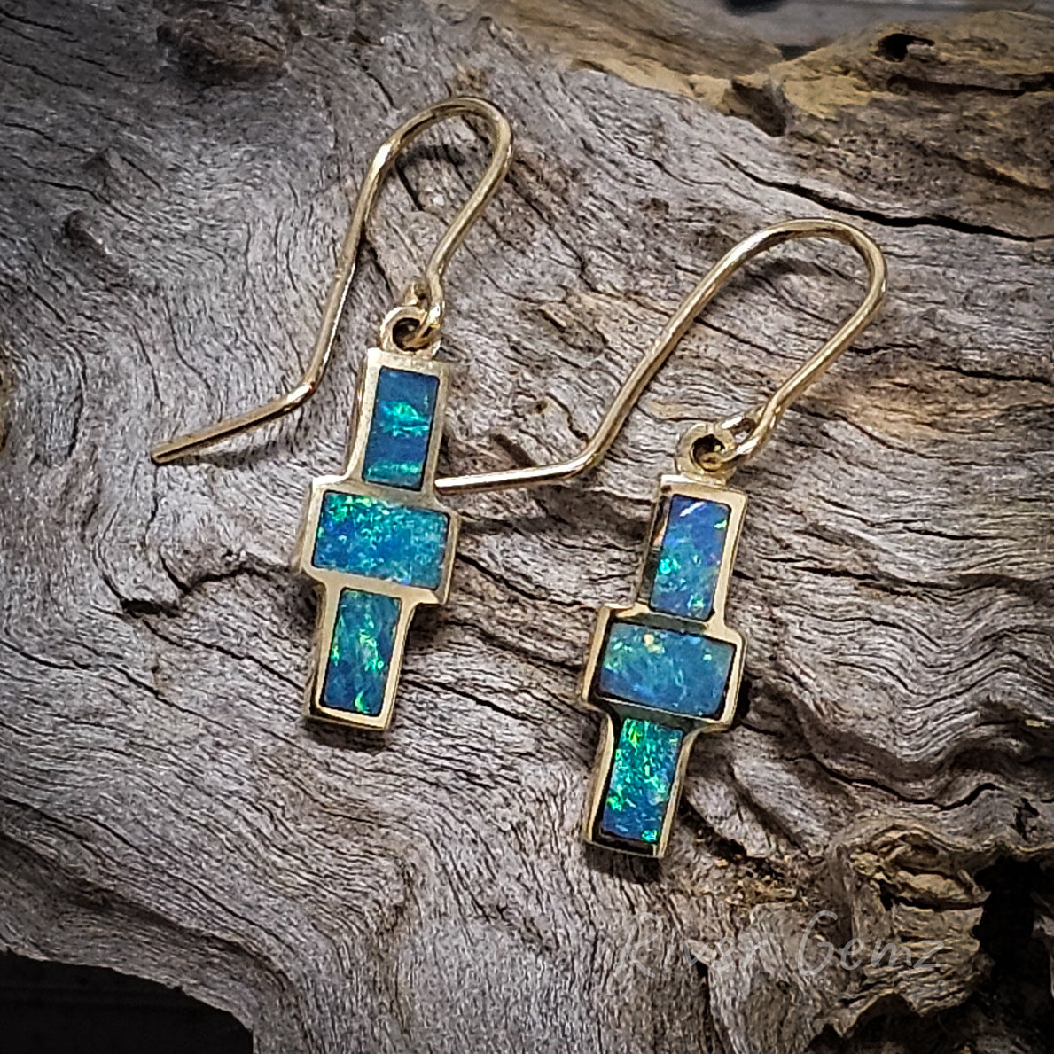 3 rectangular shaped blue-green opals arranged in a cross form these yellow gold drop earrings.