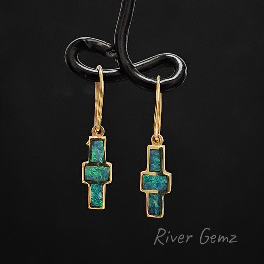 Three opals arranged in a cross form these yellow gold dangle earrings.