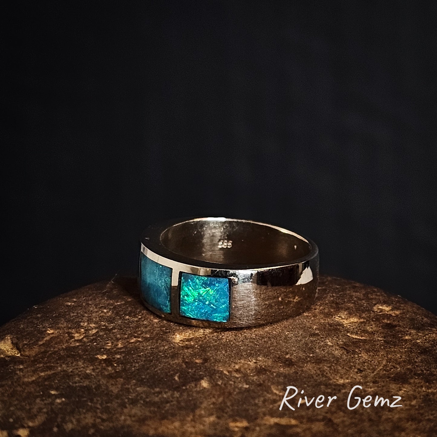 Side view of white gold ring with blue opal inlay on a dark background, branded 'River Gemz'.