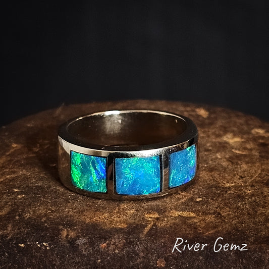 White gold ring with 3 blue/green opal stones on a dark background, branded 'River Gemz'.