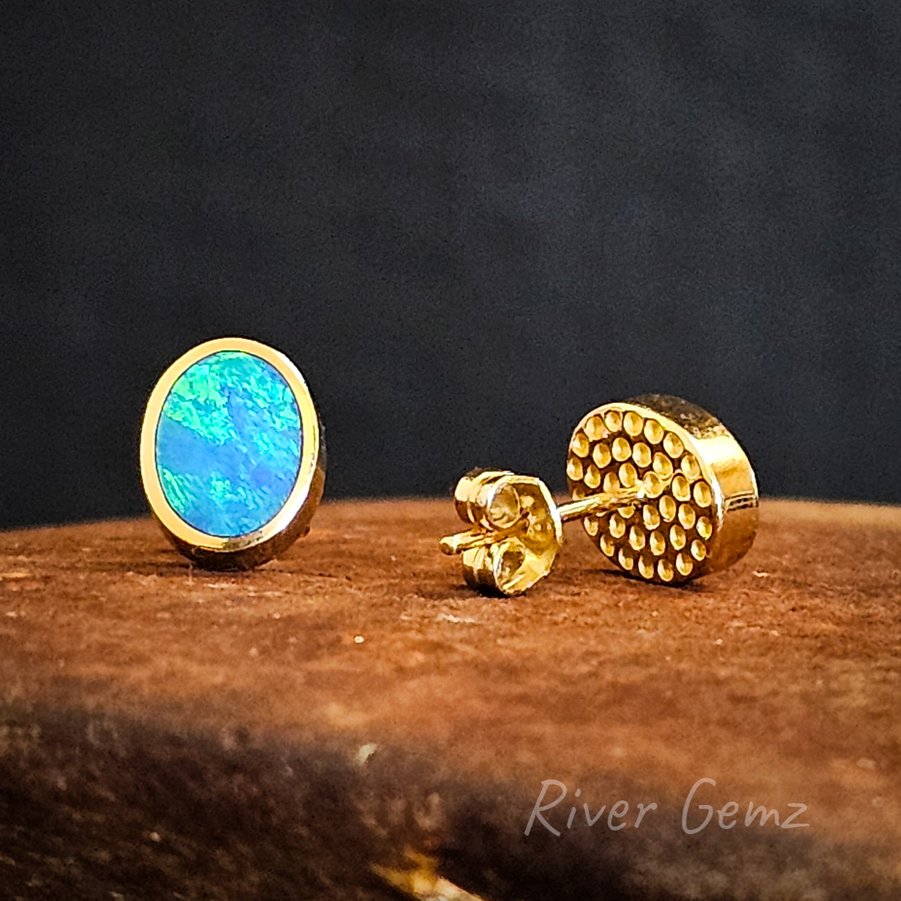 Front and rear view of the oval shaped opals in yellow gold studs.