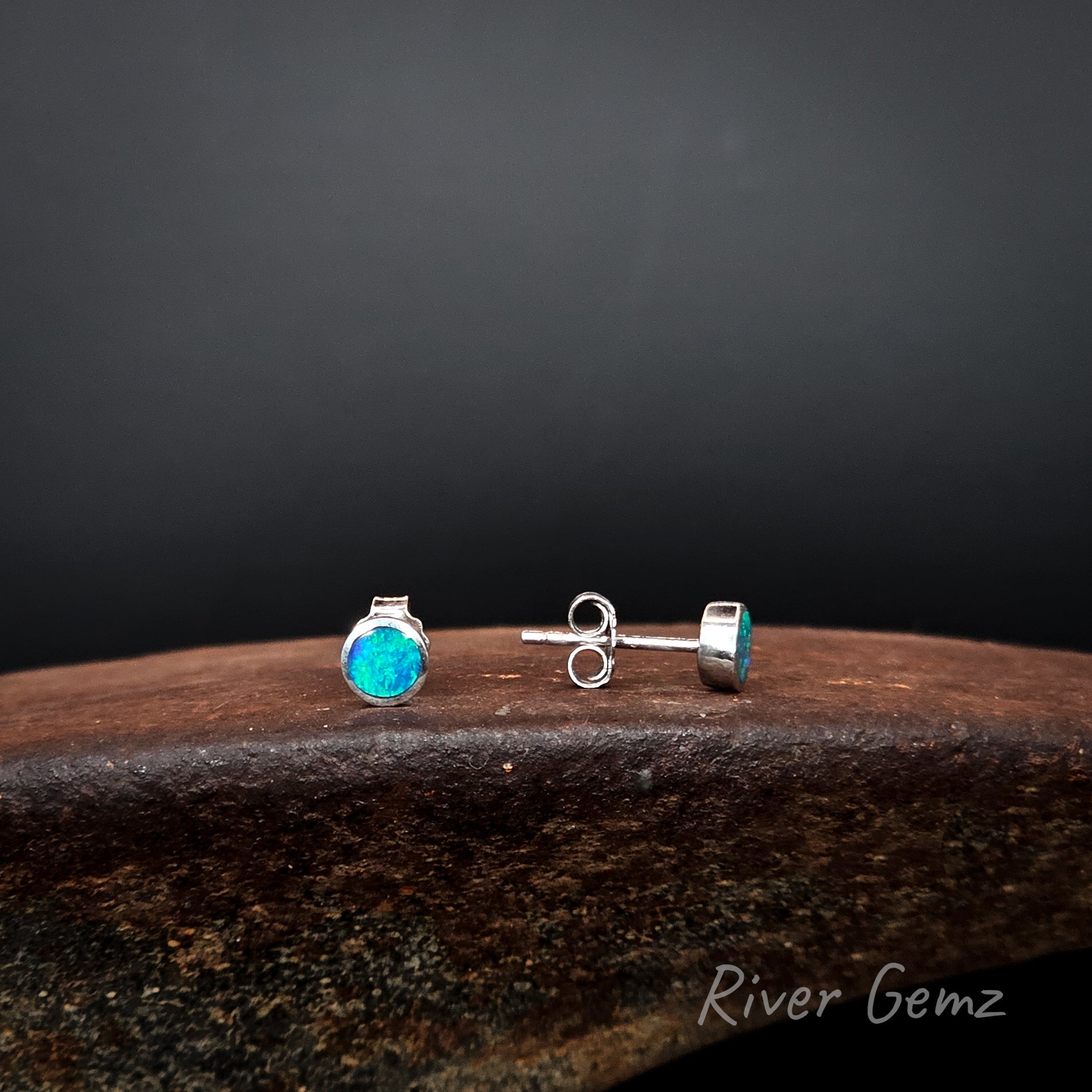 Front view of one earring and side view of the other to show the thickness of the opals set, the post length and the butterfly.